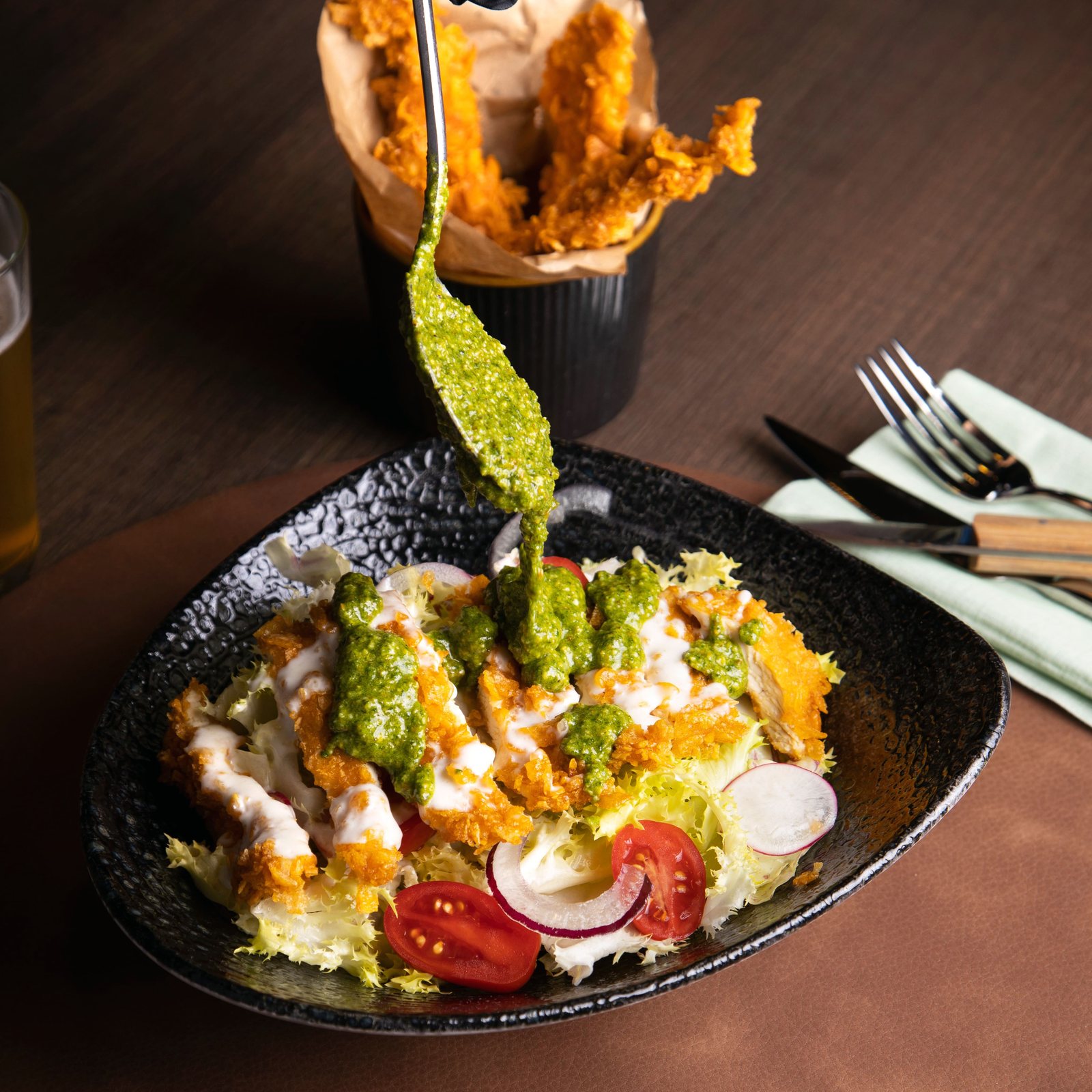 Pesto versato su un’insalata con pollo croccante